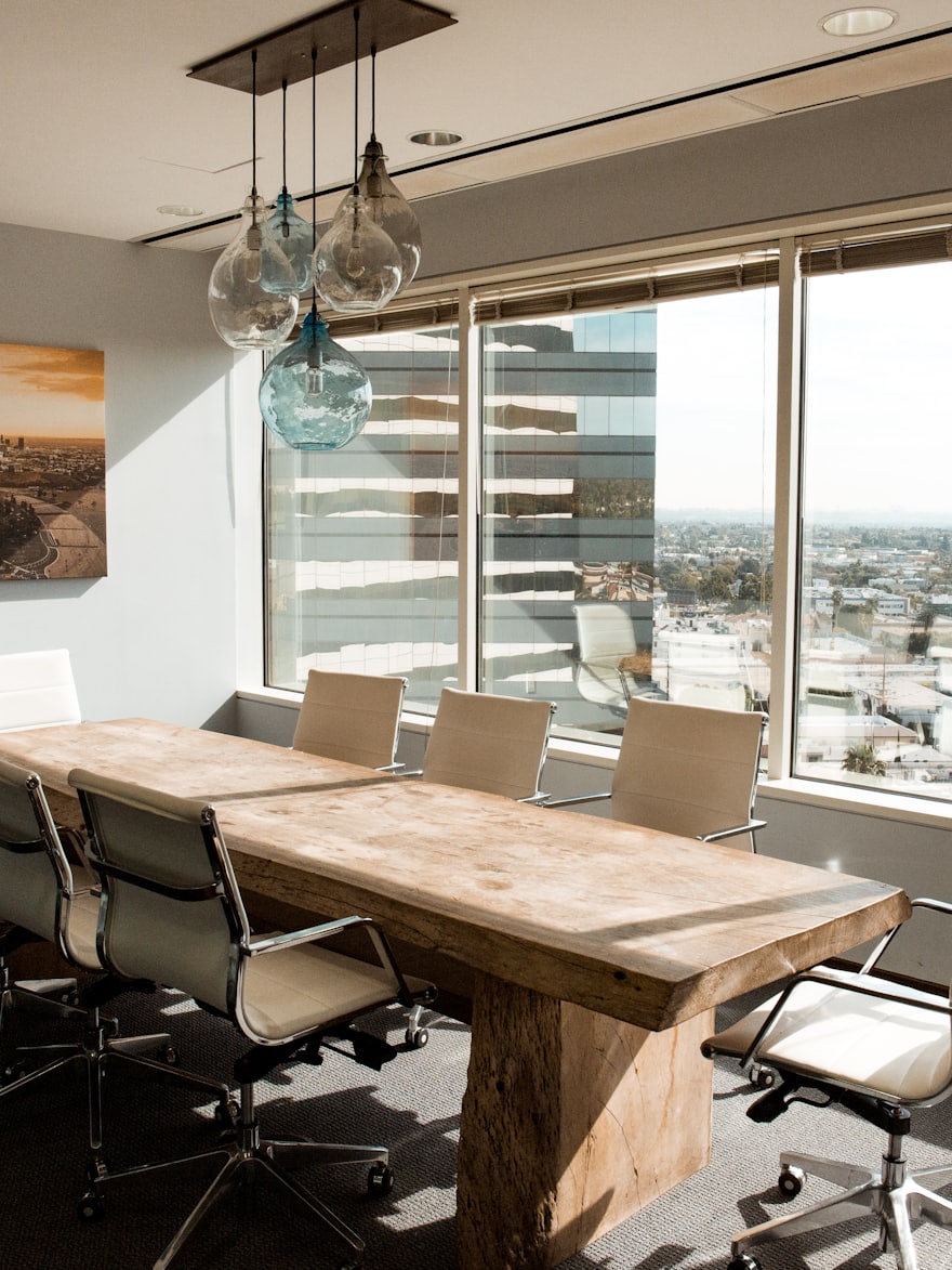 A boardroom table beside a wall of windows