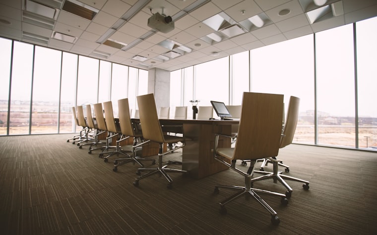 An empty boardroom with chairs along a long table