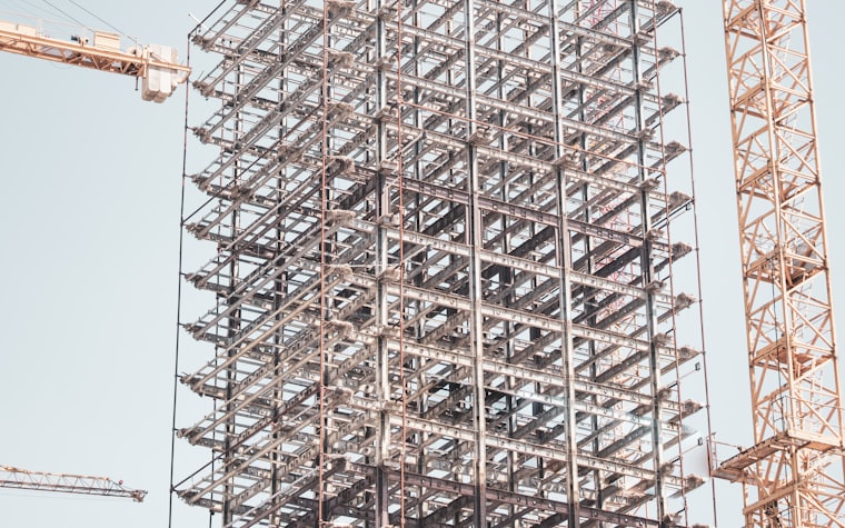 A building under construction behind tower cranes