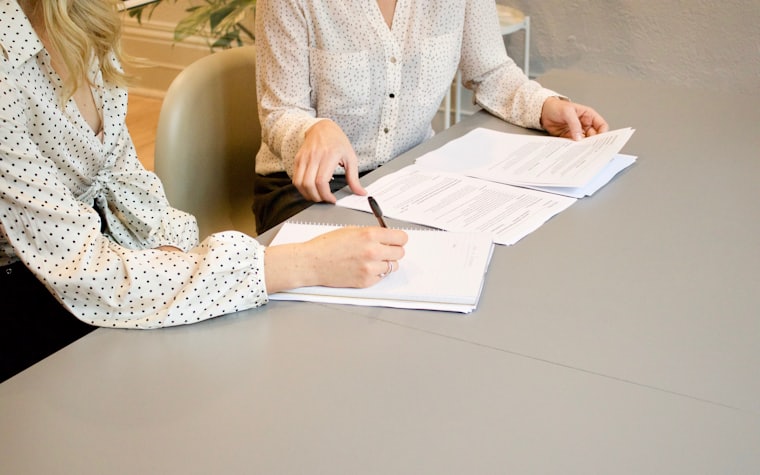 Two people reviewing paperwork across a desk