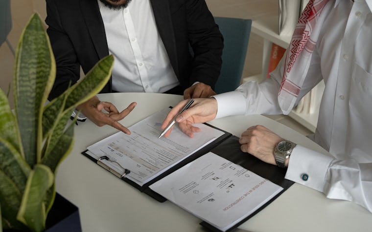 Two people signing an agreement at a table