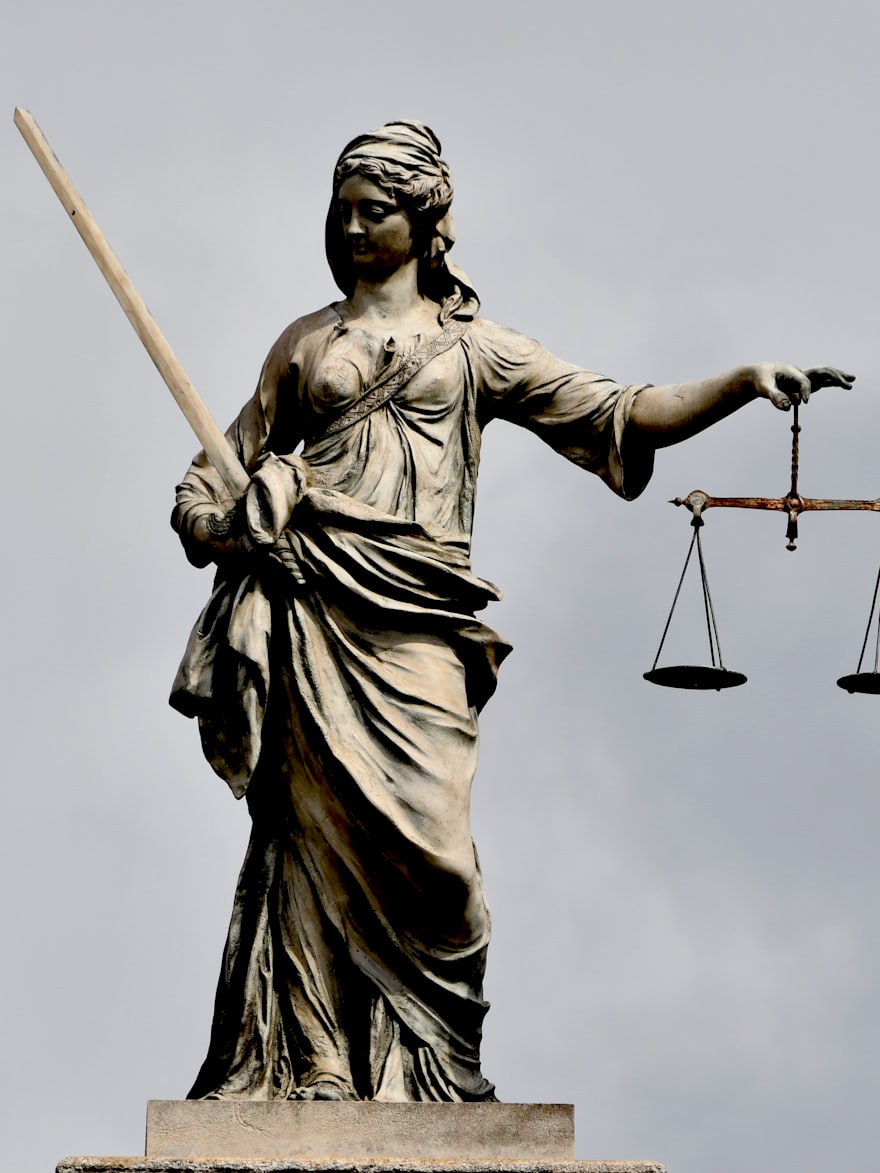 A bronze statue of Lady Justice holding scales and a sword